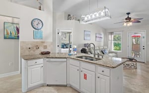Whip up your morning coffee in this bright, open kitchen featuring granite counters and modern appliances, perfectly connected to your cozy living space.