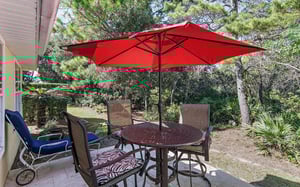 Enjoy outdoor dining on your private patio with comfortable seating surrounded by lush tropical landscaping.