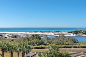 Pristine white sand beaches meet turquoise waters in this stunning coastal landscape with natural dunes and vegetation.