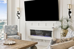 Elegant living room with a cozy fireplace, 2 large TVs, and stylish seating perfect for unwinding after your adventures.