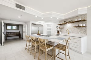 The fully equipped gourmet kitchen awaits with marble countertops, premium appliances, and stylish bar seating