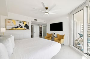 Sink into crisp white linens while golden accent chairs invite you to unwind with city views stretching beyond your private balcony.