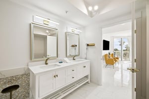 Your elegant master bathroom features dual vanities and marble finishes, connecting seamlessly to your bright bedroom with balcony views.