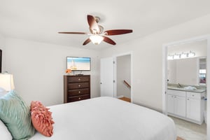 Your bright master bedroom features crisp linens, coastal touches, and an ensuite bathroom for ultimate comfort and convenience.