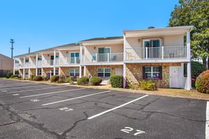 Twostory building with reserved parking spaces and landscaped grounds.
