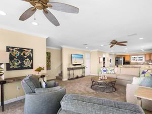 Relax in the spacious living area with coastal décor, comfortable seating, and a fully equipped kitchen.