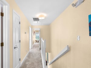 Step into this bright, welcoming hallway that connects your private spaces with warm lighting and comfortable carpet underfoot.