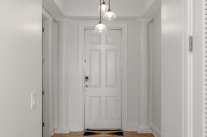 Step into your elegant entryway with soaring columns, warm pendant lighting, and classic details that welcome you home.