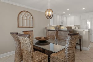 Dining space features wicker chairs around a glass table, perfect for memorable meals together.