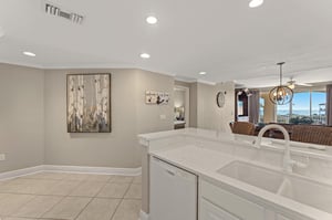 The modern kitchen flows seamlessly into the dining area, featuring gleaming quartz counters and sleek appliances for memorable meals together.