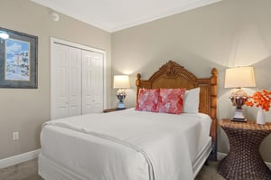 Sink into crisp white linens and tropical comfort in the peaceful bedroom retreat, complete with charming wicker touches and warm coastal lighting.