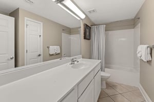 Spacious bathroom features a tub, fresh towels, and clean modern finishes for ultimate relaxation.