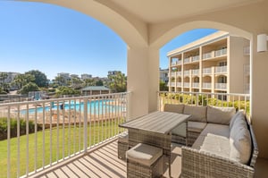 Relax on the private balcony with wicker seating while enjoying views of the sparkling pool and lush resort grounds.