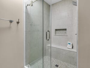 Bathroom 1 Step into your luxurious marbletiled shower with sleek glass doors, rainfall head, and builtin bench for a spalike experience.