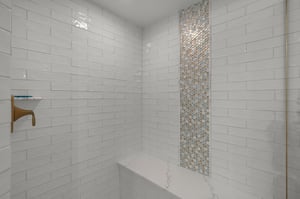 Refresh in a spalike shower with gleaming subway tiles and stunning mosaic accent wall for daily luxury.
