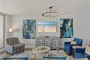 Relax in your stylish living space with coastal artwork, plush seating, and elegant lighting creating the perfect atmosphere for unwinding.