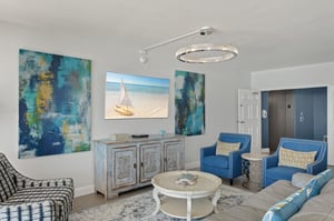 Sink into elegant comfort in your sophisticated living room, where coastal artwork and plush seating create the perfect space to unwind after beach days.