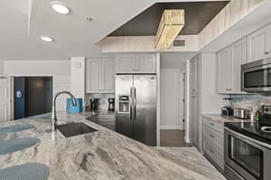 Your gourmet kitchen awaits with stunning marble countertops, stainless steel appliances, and elegant gray cabinetry—perfect for creating memorable meals during your stay.