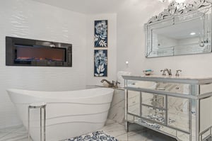 Sink into pure luxury in your spalike bathroom featuring a soaking tub, elegant mirrored vanity, and cozy fireplace for ultimate relaxation.