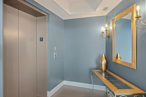 Elegant hallway with sophisticated blue walls and gold accents creates a refined atmosphere as you move through your upscale retreat.