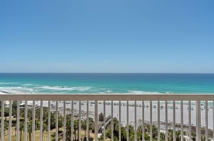 Breathtaking beachfront balcony view with pristine white sand and turquoise Gulf waters stretching endlessly before you.