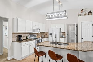 Your spacious kitchen invites culinary adventures with granite counters, modern appliances, and a breakfast bar perfect for morning coffee.