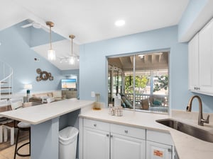 Your bright kitchen flows seamlessly to the balcony, perfect for morning coffee prep with views of lush greenery beyond.