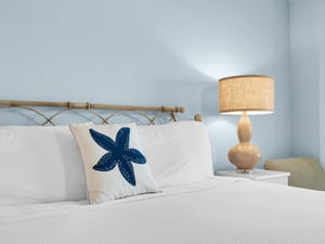 Drift off in this peaceful bedroom where coastal charm meets comfort. Crisp linens and warm lighting create your perfect seaside retreat.