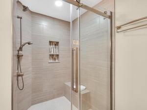 Step into your elegant glassenclosed shower with rainfall head and builtin shelving for ultimate relaxation.