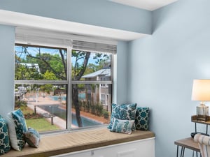 Curl up on your cozy window seat with turquoise pillows while enjoying views of the fountain and lush gardens below.