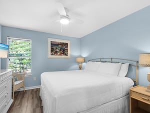 Drift off in your serene coastal bedroom, where soft blue walls and white furnishings create the perfect seaside escape for peaceful nights.