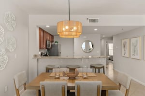 Your openconcept dining and kitchen space flows beautifully, where coastal elegance meets modern comfort for memorable meals together.
