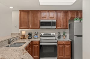 Your fully equipped kitchen features granite countertops, stainless steel appliances, and warm wood cabinetry for creating memorable meals.