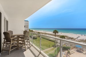 Stunning beachfront balcony with direct ocean views and comfortable outdoor dining setup.
