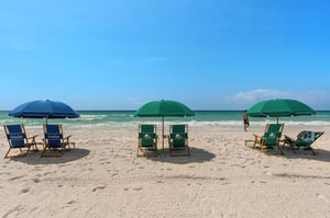 Beautiful white sand beach with colorful umbrellas and chairs set up along the pristine shoreline.
