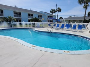 Dive into your tropical escape at this sparkling pool surrounded by swaying palms