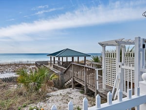 Beachfront gazebo and boardwalk provide direct access to pristine white sand and emerald waters.