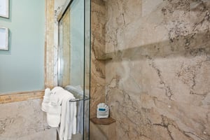 Step into the walkin shower with luxurious marble walls and fresh towels waiting for you.