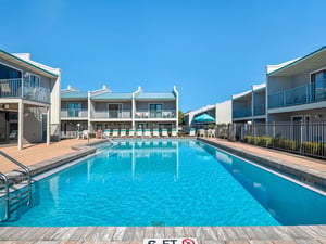 Crystalclear pool surrounded by comfortable accommodations under brilliant blue skies, creating the perfect backdrop for your relaxing getaway.