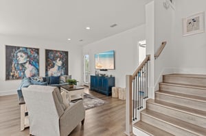 Settle into your bright, open living room with coastal art, cozy seating, and natural light—a perfect spot to unwind after exploring the area.