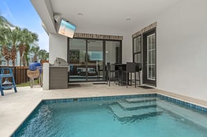 Your private patio features a sparkling plunge pool, outdoor bar seating, builtin grill, and a TV for alfresco dining and relaxing under the palms.