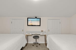 Two plush beds await your arrival, with a workspace in between for any essentials and a flatscreen TV to unwind with after your adventures.