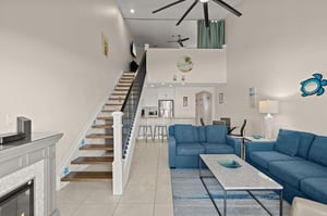 Open loftstyle retreat where soaring ceilings and coastal blues create your perfect escape. Relax on plush seating, enjoy the cozy atmosphere, and let the breezy design transport you to vacation mode