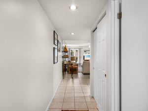 Step inside to find a bright, welcoming entryway that opens to thoughtfully decorated living spaces. The airy hall leads you past charming décor toward sunlit rooms and peaceful water views beyond.