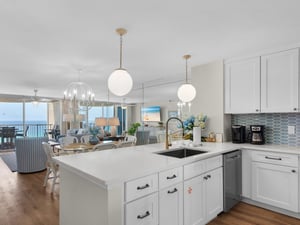 Gourmet kitchen features sleek white cabinetry and modern appliances