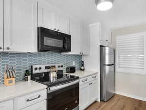 Step into your bright, fully equipped kitchen with stainless steel appliances, modern tile backsplash, and all the essentials to whip up delicious meals during your stay.