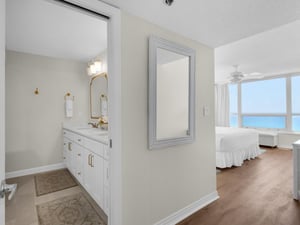Glimpse your serene oceanfront bedroom through this elegant hallway featuring a spainspired bathroom with gleaming fixtures and soothing coastal tones that invite relaxation.