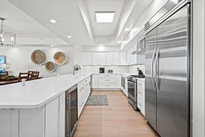 Gather, cook, and create memories in this bright, fullyequipped kitchen featuring stainless steel appliances, quartz countertops.