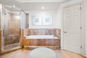 Unwind in the primary bathroom, with a soaking tub and spacious tiled shower—perfect for relaxing after a full day of adventures.