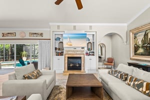 Settle into the bright living room, where beachy artwork and a cozy fireplace set the scene